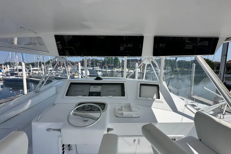 Slide: The Image of 1997 Viking 58 Convertible yacht helm with Garmin navigation, docked at marina. - 44
