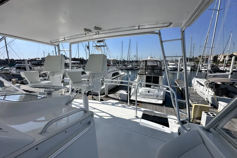 Slide: The Image of Flybridge view of a 1997 Viking 58 Convertible yacht docked at a marina. - 47