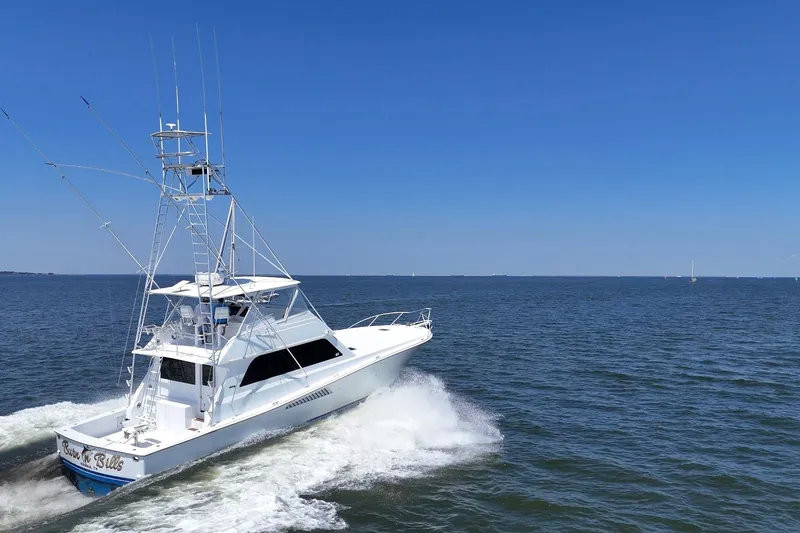 Slide: The Image of 1997 Viking 58 Convertible yacht cruising on open water under clear blue skies. - 5