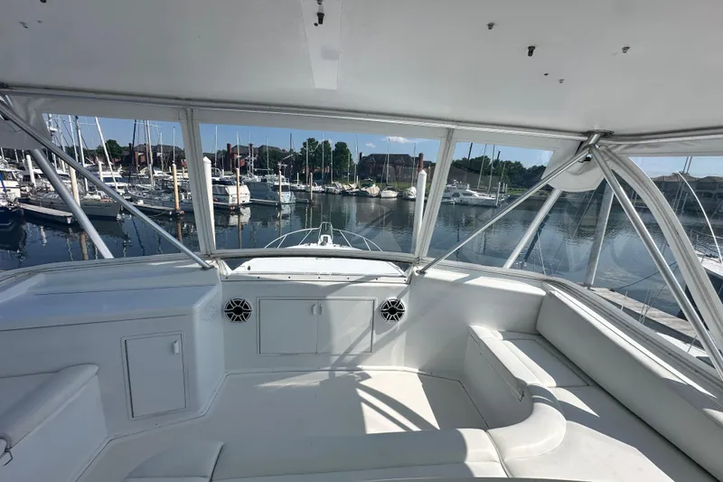 Slide: The Image of Interior view of 1997 Viking 58 Convertible yacht at marina, showcasing seating and harbor. - 50