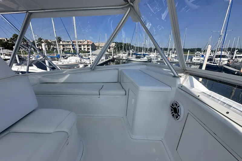 Slide: The Image of Interior view of 1997 Viking 58 Convertible yacht at marina, featuring white seating and clear windows. - 51