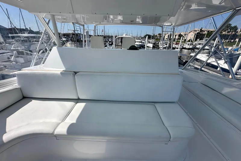 Slide: The Image of White seating area on a 1997 Viking 58 Convertible yacht, docked at a marina. - 53