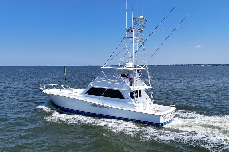 Slide: The Image of 1997 Viking 58 Convertible yacht cruising on open water under clear blue skies. - 6