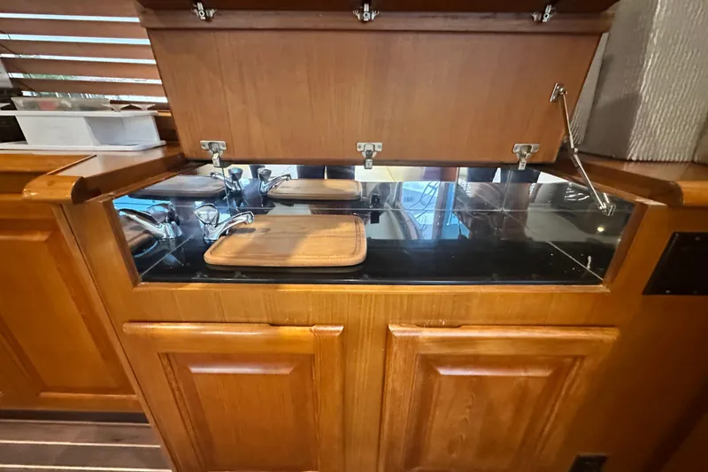 Slide: The Image of 1997 Viking 58 Convertible yacht kitchen with wooden cabinetry and hidden sink. - 63