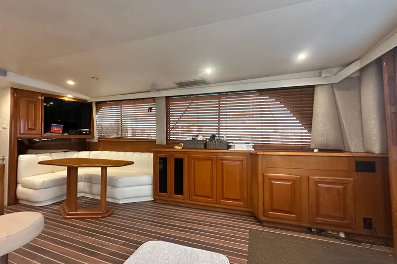 Slide: The Image of Luxurious interior of a 1997 Viking 58 Convertible yacht with wood accents and plush seating. - 64