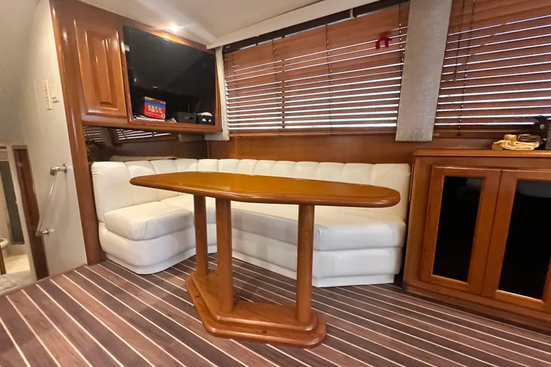 Slide: The Image of Luxurious interior of a 1997 Viking 58 Convertible yacht with white seating and wooden accents. - 65