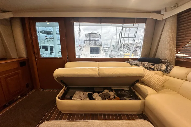 Slide: The Image of Interior of a 1997 Viking 58 Convertible yacht with storage under cream sofa. - 69