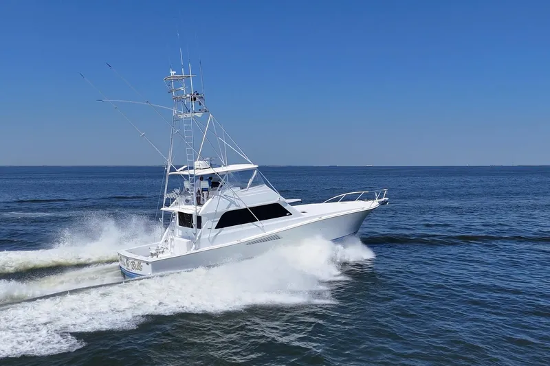 Slide: The Image of 1997 Viking 58 Convertible yacht cruising on open sea under clear blue sky. - 7