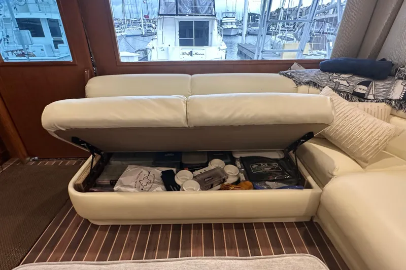 Slide: The Image of Interior of 1997 Viking 58 Convertible yacht with storage under cream sofa. - 70