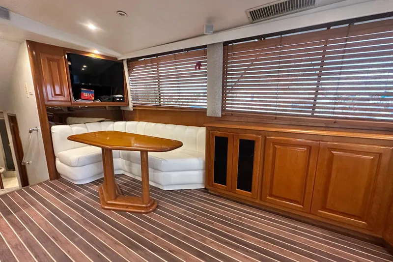 Slide: The Image of Luxurious interior of 1997 Viking 58 Convertible yacht with wood accents and white seating. - 74