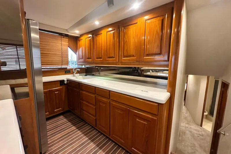 Slide: The Image of Luxurious kitchen interior of 1997 Viking 58 Convertible yacht with wooden cabinets and modern appliances. - 79