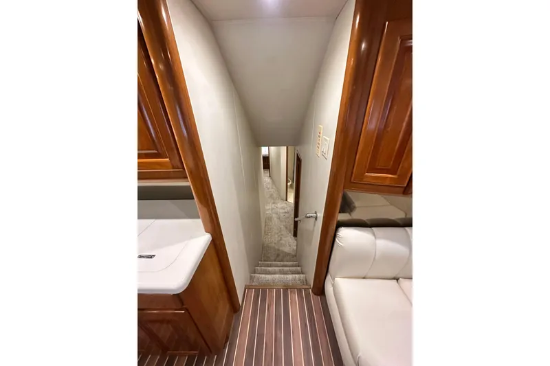 Slide: The Image of Interior view of 1997 Viking 58 Convertible yacht, featuring wooden cabinetry and carpeted stairs. - 86