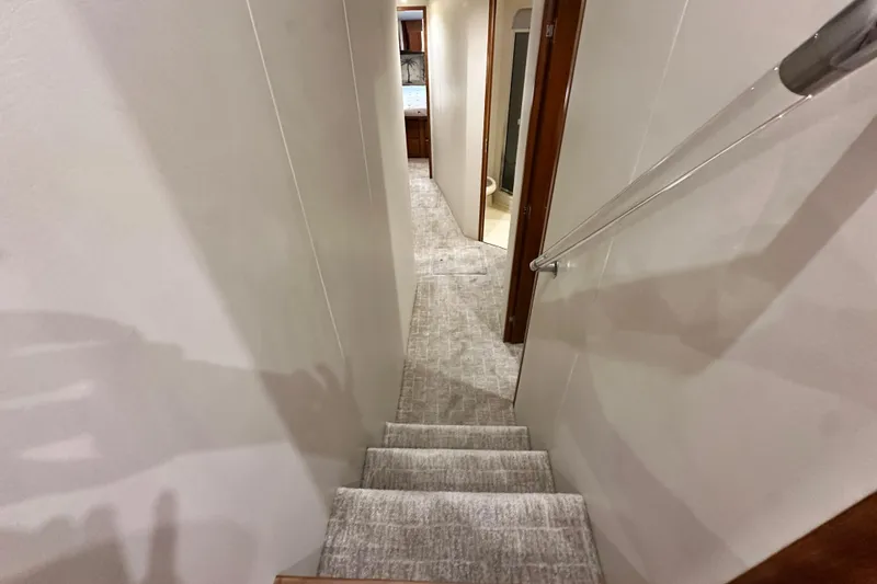 Slide: The Image of Interior hallway of a 1997 Viking 58 Convertible yacht with carpeted stairs and handrail. - 87
