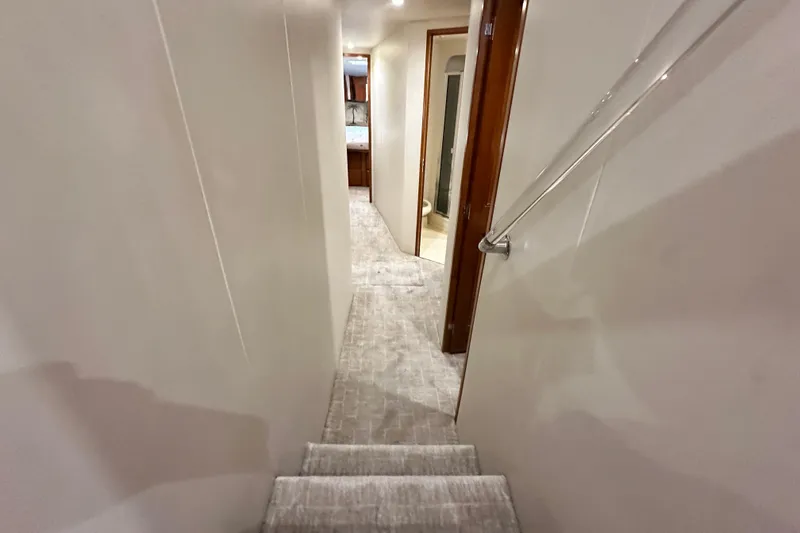 Slide: The Image of Interior hallway of a 1997 Viking 58 Convertible yacht, featuring carpeted stairs and sleek design. - 88