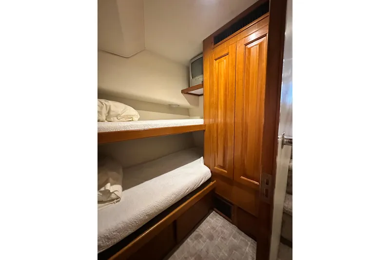 Slide: The Image of Interior of 1997 Viking 58 Convertible yacht with wooden bunk beds and closet. - 89