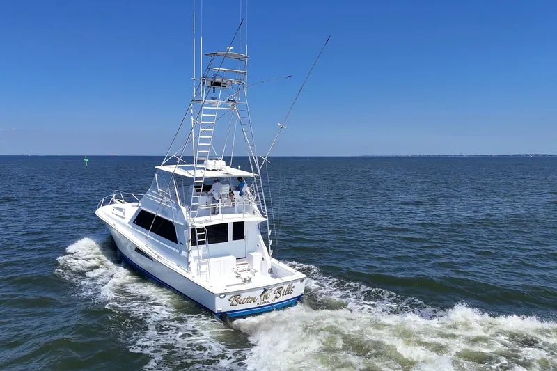 Slide: The Image of 1997 Viking 58 Convertible yacht cruising on open water under clear blue skies. - 9