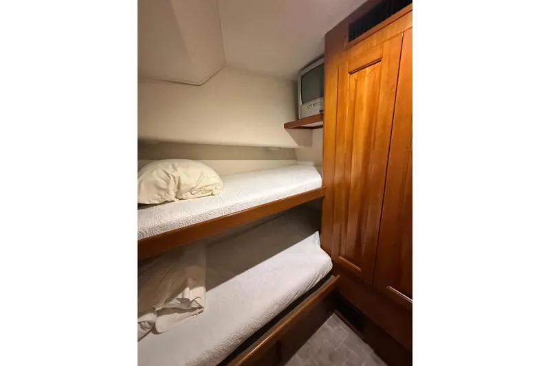 Slide: The Image of Bunk beds in a 1997 Viking 58 Convertible yacht cabin with wooden cabinetry. - 93
