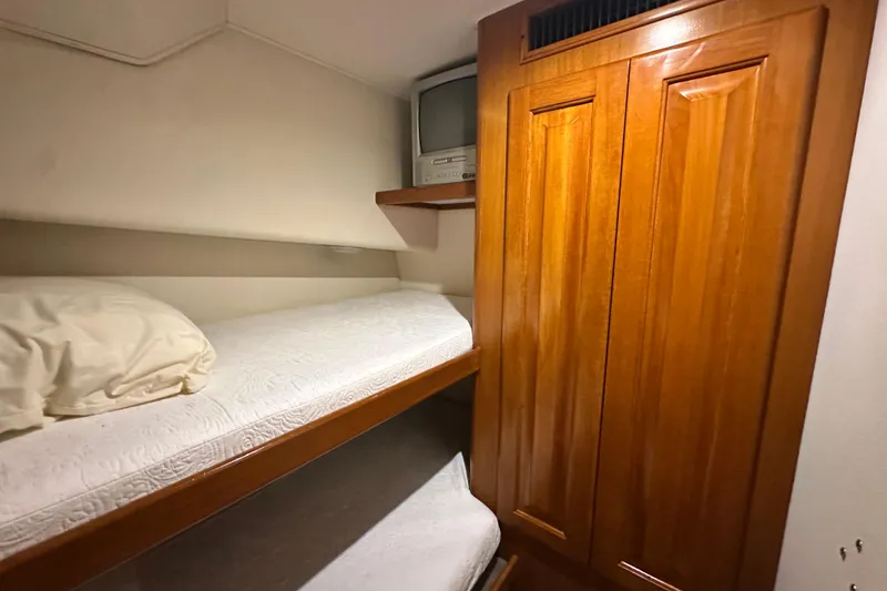 Slide: The Image of Interior of 1997 Viking 58 Convertible yacht with bunk beds and wooden cabinetry. - 94