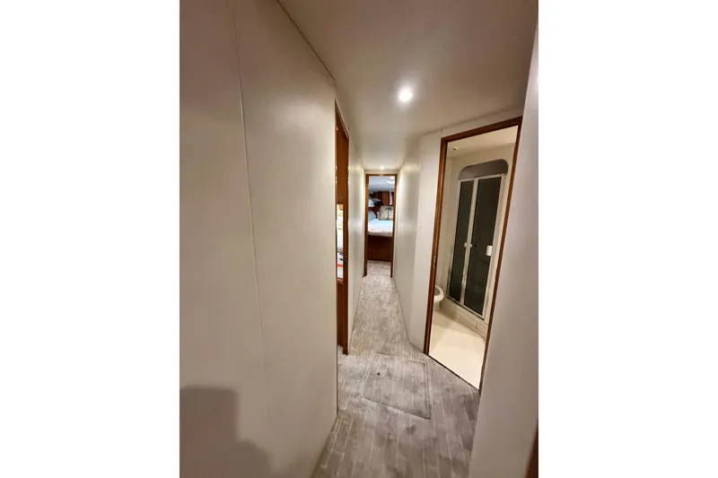 Slide: The Image of Hallway inside 1997 Viking 58 Convertible yacht, featuring modern design and wooden flooring. - 95