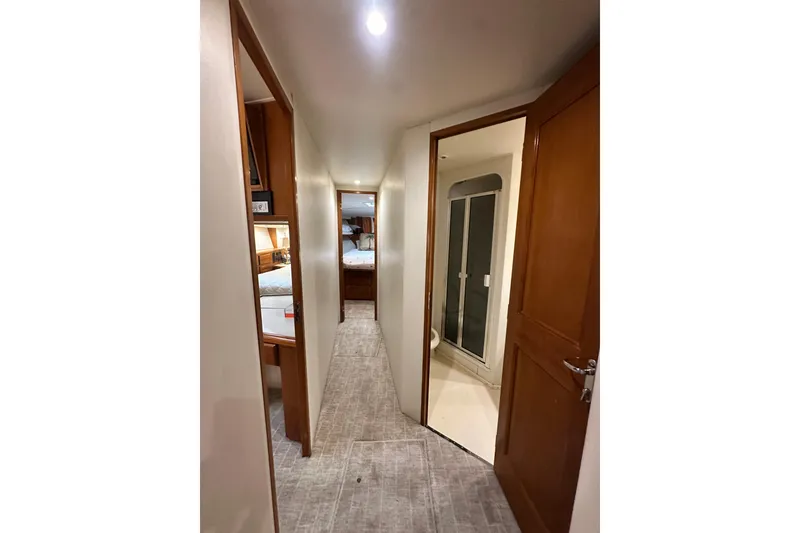 Slide: The Image of Hallway inside 1997 Viking 58 Convertible yacht, featuring wooden doors and carpeted flooring. - 96