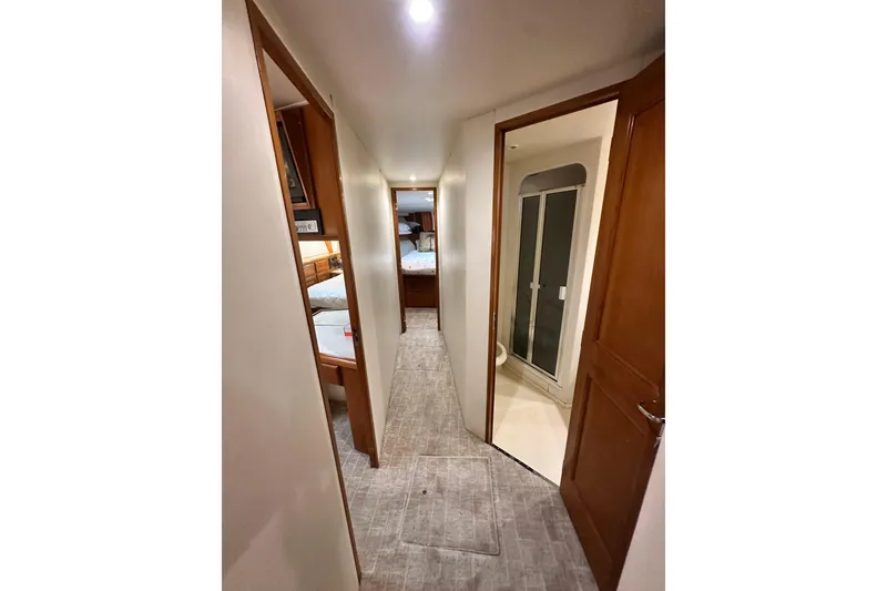 Slide: The Image of Hallway inside 1997 Viking 58 Convertible yacht, featuring bedrooms and bathroom access. - 97