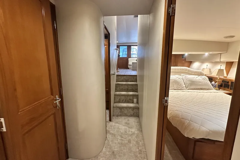 Slide: The Image of Interior of 1997 Viking 58 Convertible yacht, featuring hallway, stairs, and cozy bedroom. - 98