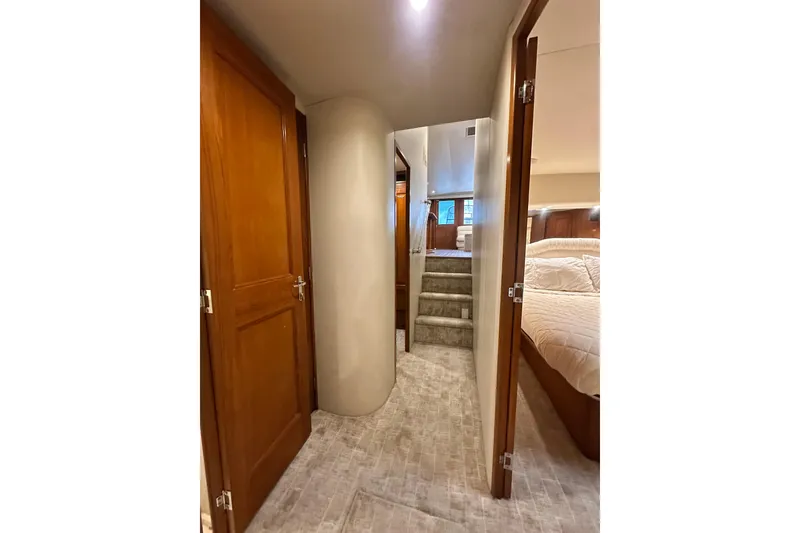Slide: The Image of Interior hallway of 1997 Viking 58 Convertible yacht with wooden doors and carpeted stairs. - 99