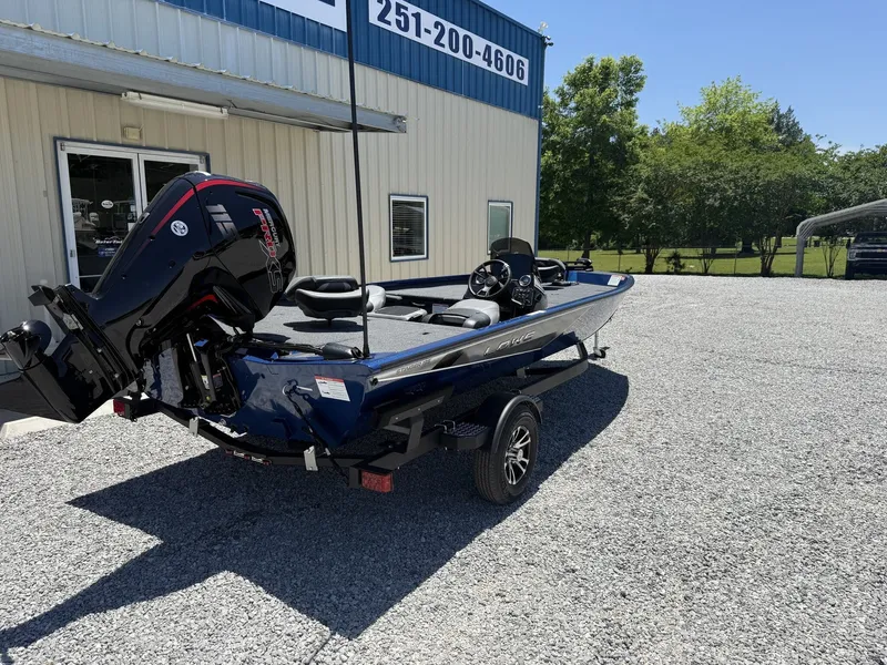 Slide: The Image of 2026 Lowe Stinger 195 Bass boat on gravel lot outside building. - 4