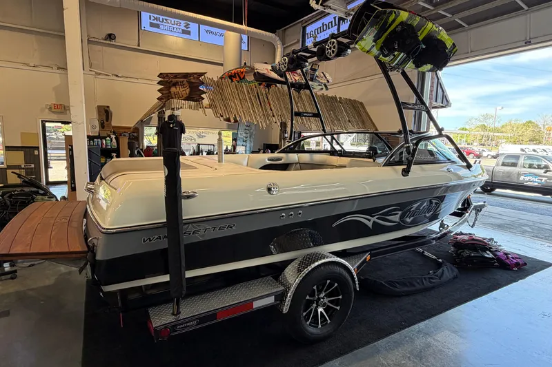 Slide: The Image of 2003 Malibu Wakesetter 21 VLX boat in showroom, featuring wakeboards and trailer. - 3
