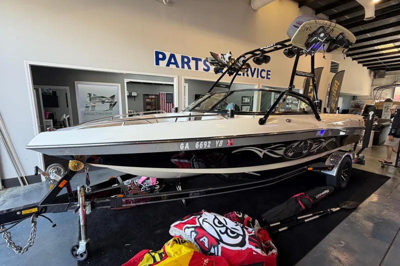 The Image of 2003 Malibu Wakesetter 21 VLX boat in showroom, featuring sleek design and accessories. - 0