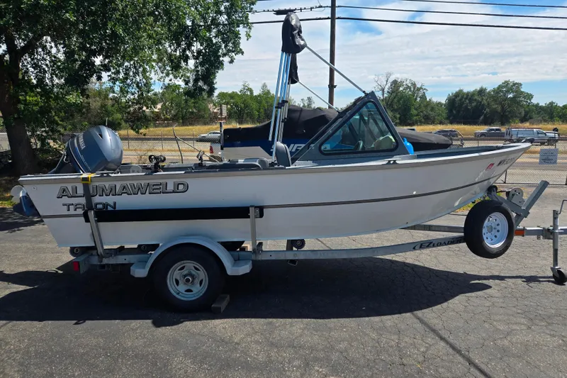 Slide: The Image of 2016 Alumaweld Talon 16 boat on trailer, parked outdoors under clear sky. - 12