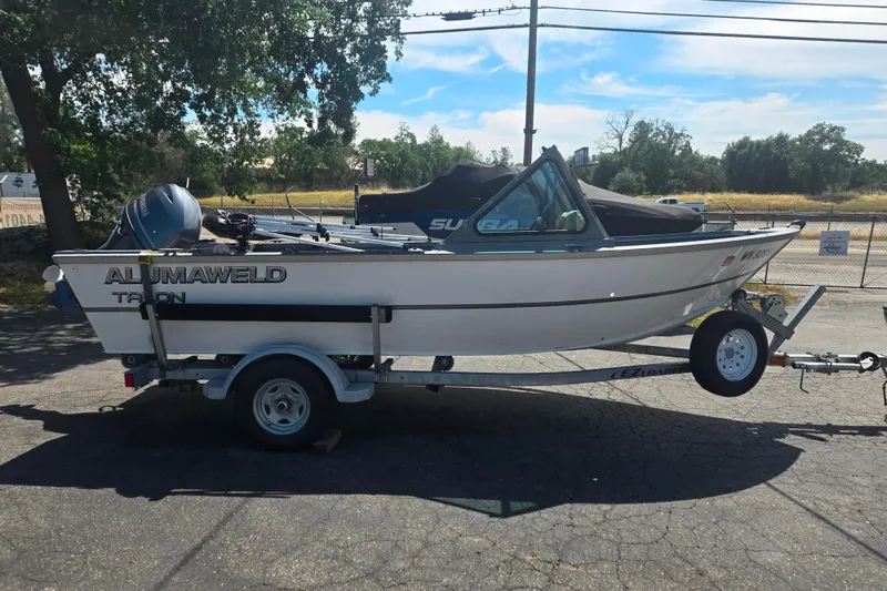 Slide: The Image of 2016 Alumaweld Talon 16 boat on trailer, parked outdoors under a clear sky. - 13