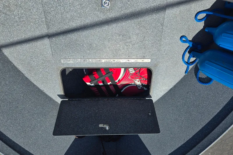 Slide: The Image of Storage compartment on 2016 Alumaweld Talon 16 boat with life jackets and blue ropes. - 8