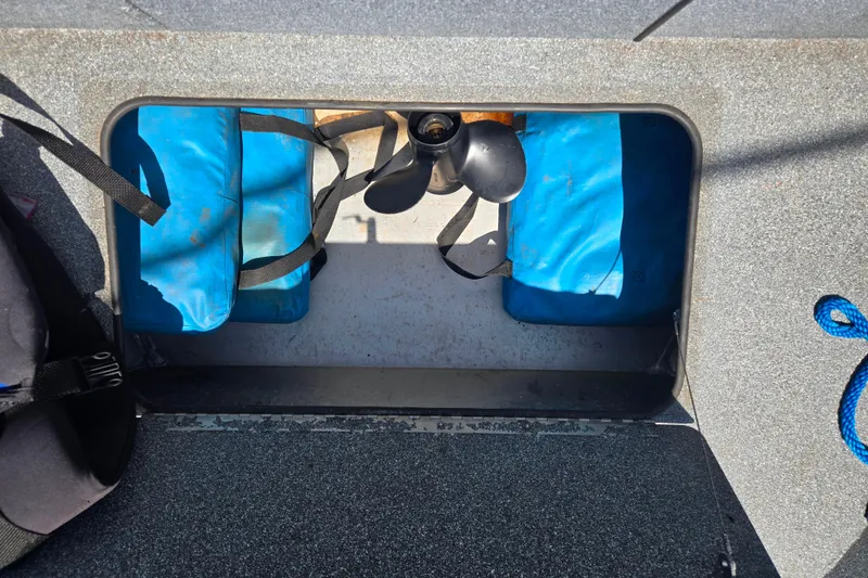 Slide: The Image of 2016 Alumaweld Talon 16 boat compartment with blue flotation bags and propeller. - 9