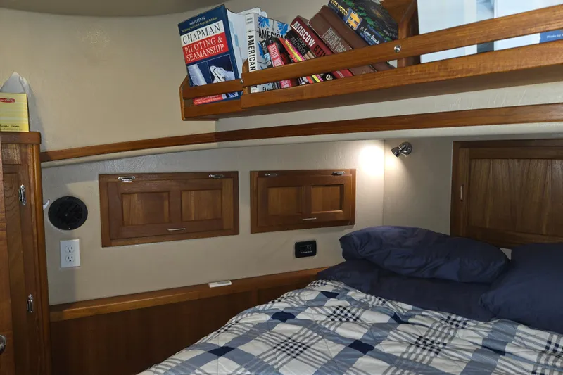 Slide: The Image of Cozy cabin interior of 2006 American Tug 34 Pilothouse Trawler with books and plaid bedding. - 12