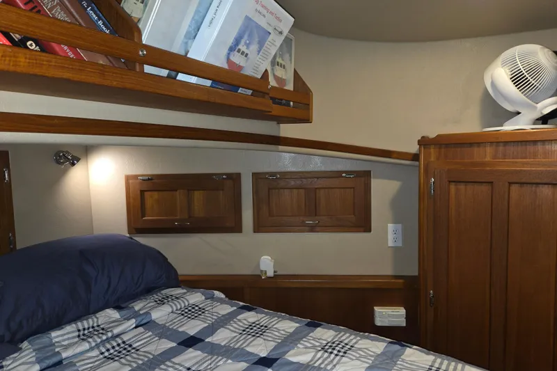 Slide: The Image of Cozy cabin interior of 2006 American Tug 34 Pilothouse Trawler with wooden cabinetry and bedding. - 13