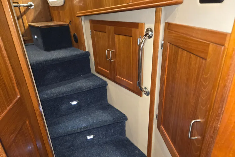 Slide: The Image of Interior stairs of 2006 American Tug 34 Pilothouse Trawler with wooden cabinets and carpeted steps. - 19