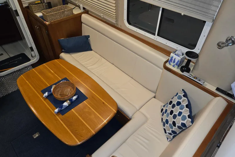 Slide: The Image of Interior of 2006 American Tug 34 Pilothouse Trawler with cozy seating and wooden table. - 20