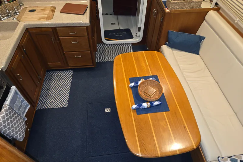 Slide: The Image of Interior of 2006 American Tug 34 Pilothouse Trawler with wooden table and cozy seating. - 21