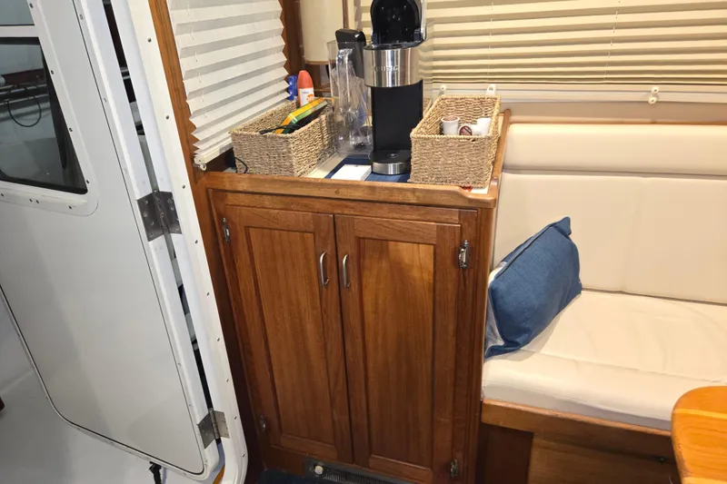 Slide: The Image of Cozy interior of 2006 American Tug 34 Pilothouse Trawler with wooden cabinet and seating area. - 22