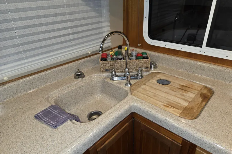Slide: The Image of Kitchen sink area in 2006 American Tug 34 Pilothouse Trawler with faucet and cutting board. - 27