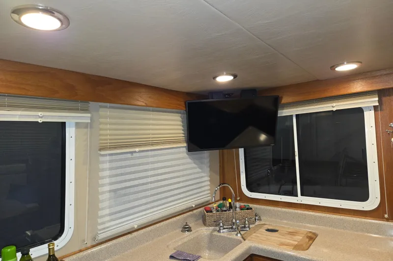 Slide: The Image of Interior of 2006 American Tug 34 Pilothouse Trawler with kitchen sink, TV, and windows. - 28