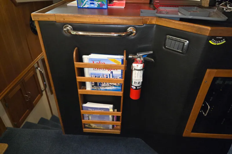 Slide: The Image of Interior of 2006 American Tug 34 Pilothouse Trawler with books and fire extinguisher. - 34