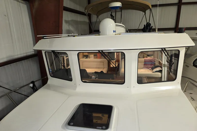Slide: The Image of 2006 American Tug 34 Pilothouse Trawler in storage, showcasing interior through large windows. - 44
