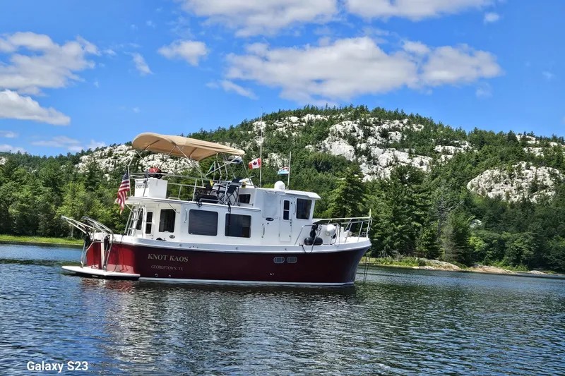 Slide: The Image of 2006 American Tug 34 Pilothouse Trawler on scenic lake with forested hills. - 57
