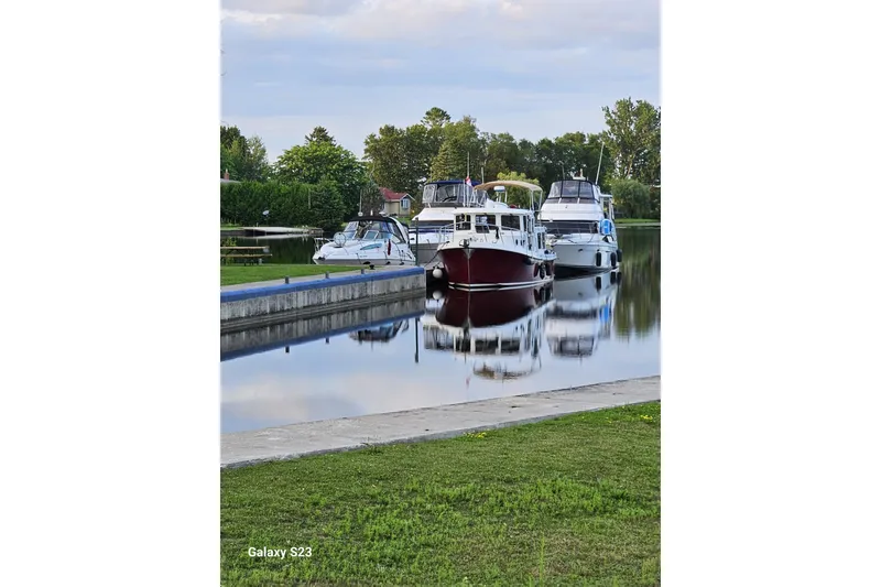 Slide: The Image of American Tug 34 Pilothouse Trawler, 2006, docked in a serene marina setting. - 58