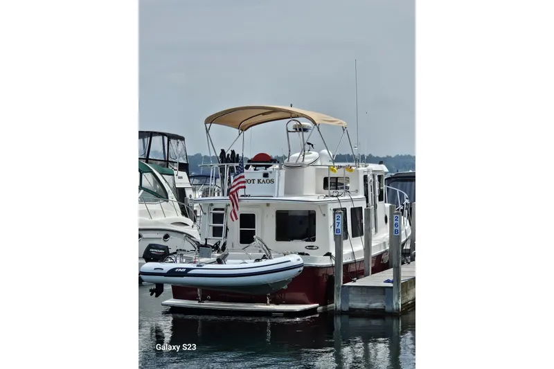 Slide: The Image of 2006 American Tug 34 Pilothouse Trawler docked with inflatable boat and American flag. - 61