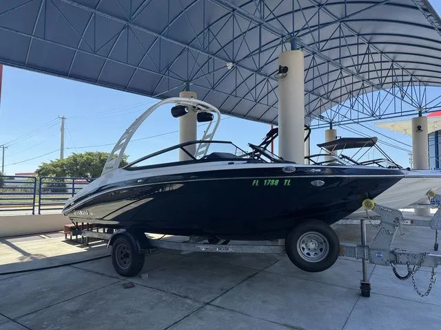 Slide: The Image of 2023 Yamaha Boats 195S on trailer under canopy. - 18