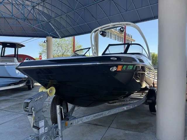 Slide: The Image of 2023 Yamaha Boats 195S on trailer under canopy. - 23