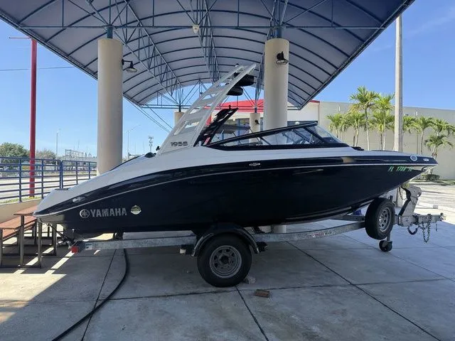 Slide: The Image of 2023 Yamaha Boats 195S on a trailer under a canopy. - 24